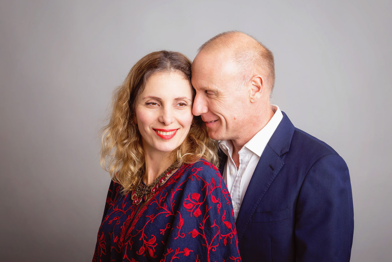 A portrait of a couple taken in a studio set up with backdrop and lighting equipment
